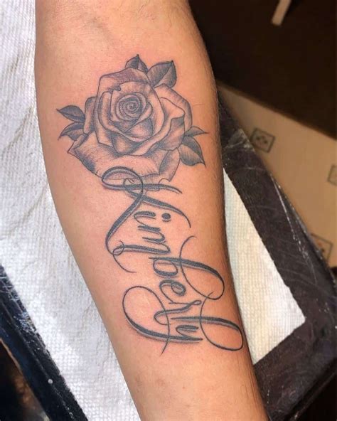 female rose tattoo with name inside